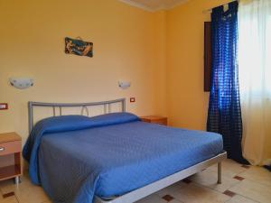 Deliceto科勒得艾尔策旅馆的一间卧室配有一张带蓝色床单的床和一扇窗户。
