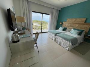桑坦德利亚湾Hotel Playa Santandria Adults Only的一间卧室配有两张床和一张书桌及电视