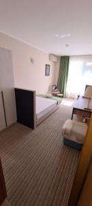 布尔加斯米拉娜家庭酒店的一间卧室设有一张大床和一个大窗户