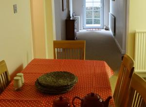 亨斯坦顿The Garden Flat的一间设有一张桌子的房间,配有红色的波尔卡圆桌布