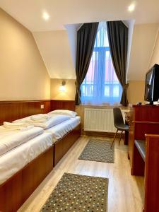 考波什堡Borostyán Panzió的一间卧室配有两张床、一张桌子和一台电视。