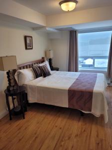卡灵港Muskoka Lakes Hotel and Resorts的一间卧室设有一张大床和一个大窗户