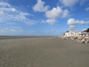 滨海卡约gite repos et tranquillité P的一片拥有岩石、蓝天和云的海滩