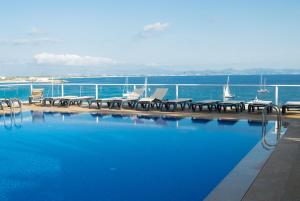 埃斯普霍斯桑威蓬塔俱乐部高级酒店的水边带桌椅的游泳池