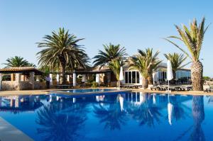 埃斯普霍斯桑威蓬塔俱乐部高级酒店的棕榈树度假村前的游泳池