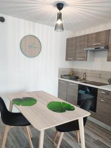 布雷斯特Joli appartement avec jardin-terrasse privé的厨房配有木桌和一些椅子
