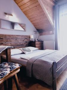 梅希莱尼采Podkowa的一间卧室设有两张床和木制天花板