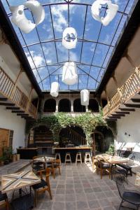 库斯科Casa Tunki的配有桌椅和玻璃天花板的房间