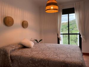贝纳马奥马Suite Rural Oasis的一间卧室设有一张床和一个美景窗户。