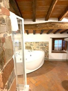 基安蒂格雷夫卡萨莱勒马斯住宿加早餐旅馆的一间石墙内带浴缸的浴室