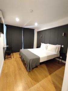 比索达雷加Residencial Douro的一间卧室设有一张大床,铺有木地板