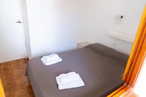 阿雷纳尔登卡斯特尔Apartamento Menorca Arenal d'en Castell的一间卧室配有一张床,上面有两条毛巾