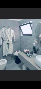 Dorבלקוני לחוף דור的浴室设有水槽和带白色浴袍的台面。