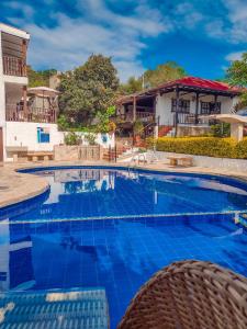 莫尼基拉Hotel Casona del Virrey的一座大游泳池,位于房子前面,铺有蓝色瓷砖