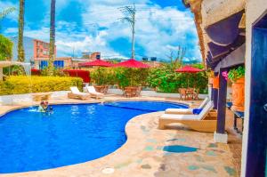 莫尼基拉Hotel Casona del Virrey的一个带椅子和遮阳伞的游泳池