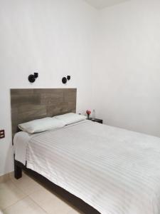 加尔潘Hotel Santa Lucia的一间卧室配有一张带白色床单的大床