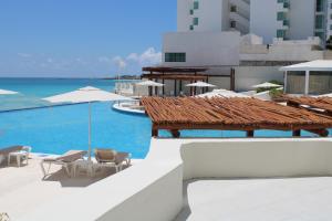 坎昆Cyan Cancun Resort & Spa的一个带游泳池和椅子的度假胜地和大海