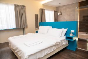 那不勒斯South Hands Luxury Rooms的一张大床,在房间内有一个蓝色床头板