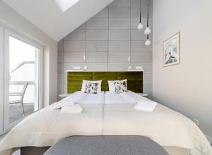 雷瓦Villa Natura Rewa的卧室配有一张带两个枕头的大白色床