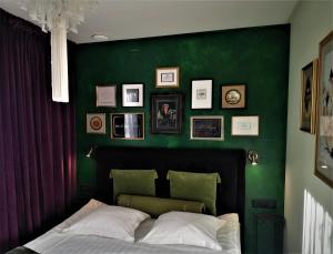 库雷萨雷Vinoteegi Residents的一间卧室设有一张带床铺的绿色墙壁