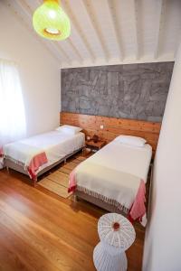 圣罗克杜皮库Adega Baía Azul - The essence of Pico的一间卧室设有两张床和石墙