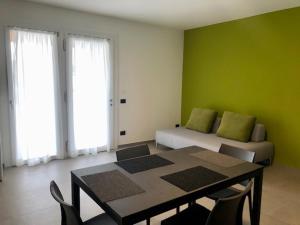 拉齐塞Corte Rocchetti Suite的一间设有桌子和一张带绿色墙壁的床的房间