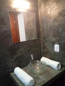 特雷索波利斯Pousada Tarkna的浴室配有盥洗盆、镜子和毛巾