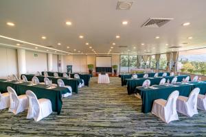 瓦哈卡市瓦哈卡维多利亚酒店的配有绿色和白色桌椅的房间