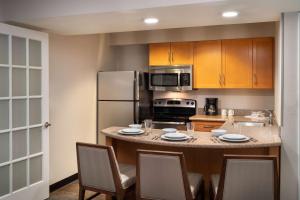 坦培Sonesta ES Suites Tempe的厨房配有桌椅和冰箱。