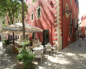 赫罗纳传奇赫罗纳博物馆酒店的红色建筑旁带桌椅的庭院