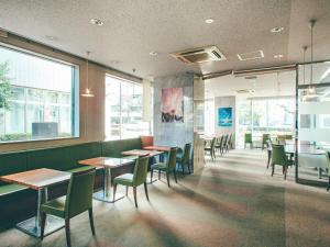 冈山冈山吴竹酒店的用餐室设有桌椅和窗户。
