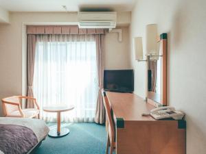 冈山冈山吴竹酒店的酒店客房设有一间带书桌和床的卧室