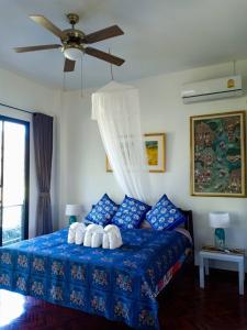 范县哥亚之家旅馆的一间卧室配有一张蓝色的床和吊扇