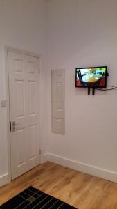 伦敦牧羊人布什公寓的一间房间,墙上挂着电视,门