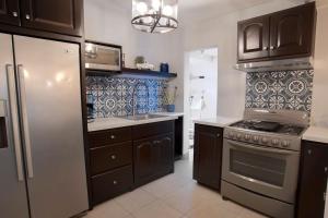 恩塞纳达港Clean&Equipped, 1-Floor 3-Bedroom Downtown House的厨房配有冰箱和炉灶。 顶部烤箱