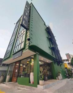 曼谷VIVA LA VIDA HOTEL的绿色建筑的侧面有标志