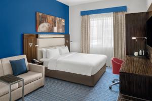 迪拜沙发公园快捷假日酒店的配有一张床和一把椅子的酒店客房
