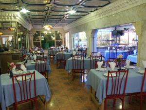 哈马马特汉密尔顿酒店的餐厅配有桌椅和蓝桌布