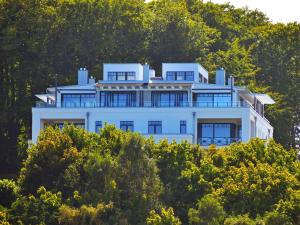 奥斯赛拜-塞林Villa Claire - Meerblicksuite "Sunrise Queen"的山顶上一座白色的大房子
