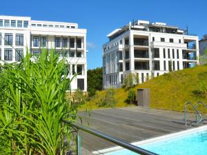 奥斯赛拜-塞林Villa Claire - Meerblicksuite "Sunrise Queen"的享有两栋建筑和游泳池的景致