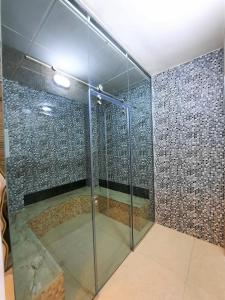 锡卜Diamond Star Hotel فندق النجمة الماسية的一间房间里带玻璃门的淋浴
