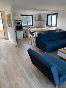 BoharsMaison contemporaine aux portes de Brest的一间带蓝色沙发的客厅和一间厨房