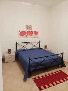 伯吉维奇Casa Sole e Vento的一间卧室配有蓝色的床和红色地毯