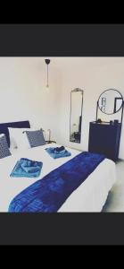 Dorבלקוני לחוף דור的一间卧室配有一张大床,配有蓝色的床单和镜子