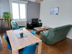 波城Appartement dans Villa的客厅配有木桌和椅子