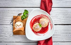 Neustift im MühlkreisGasthaus Wundsam的桌上的红色甜点,上面有白盘