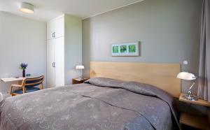 斯普恩萨杜尔哈尼亚尔高地中心旅馆的一间卧室配有一张床、一张桌子和一张桌子。
