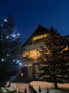 杜劳Casa Cris的圣诞树在一座有圣诞灯的房子前