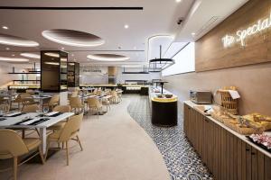 贝尼多姆Hotel Gold Arcos 4 Sup - Built in May 2022的一间带桌椅的餐厅和一间自助餐厅
