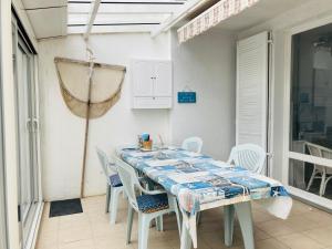 圣让-德蒙Maison des loriots, charme marin, plage à 100m的客房内的白色桌椅